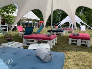 Wystrój i aranżacja siedzisk  i stołów pod namiotem w trakcie pikniku. 